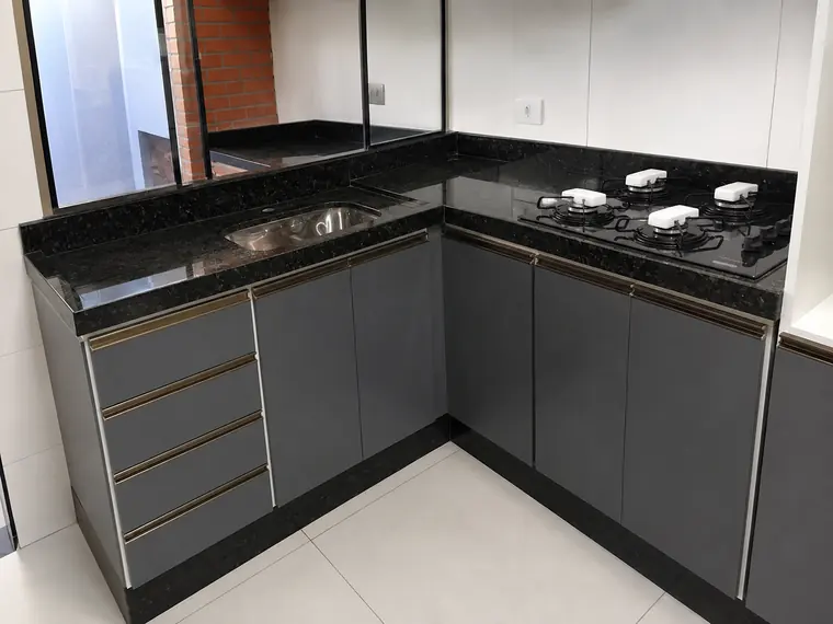Cozinha planejada cinza com bancada de granito preto
