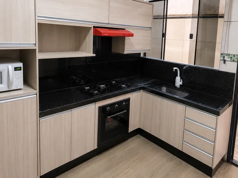 Cozinha planejada clara com bancada de granito preto